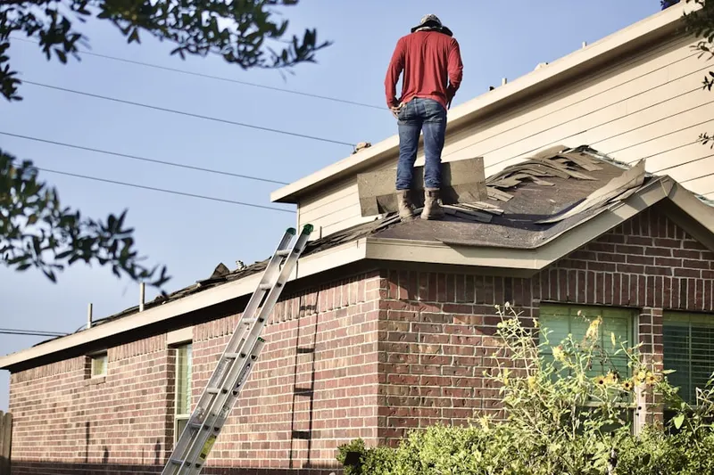 Professional roofer working on a residential roof in Dinuba